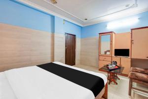 a bedroom with a bed and a table and a television at Collection O Rayagada Bus Stand in Rāyagada