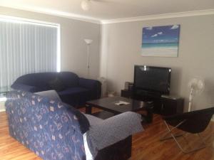 a living room with a couch and a tv at Mystic Blue in Nowra