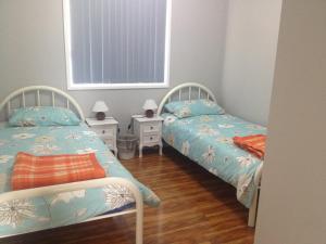 two twin beds in a room with wooden floors at Mystic Blue in Nowra