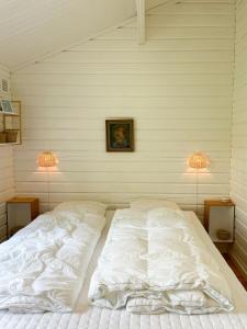 a white bed in a room with two lamps at Fine Details In Forest Setting In Ebeltoft in Ebeltoft +12 photos