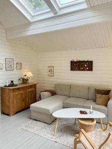 a living room with a couch and a table at Fine Details In Forest Setting In Ebeltoft in Ebeltoft