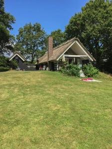a house with a grass yard in front of it at Retro Idyll And Bird Sounds In Quiet Oasis in Asperup
