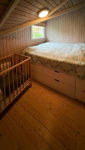 Habitación pequeña con cama y cuna en Charming Summerhouse With A View Of The Limfjord, en Roslev