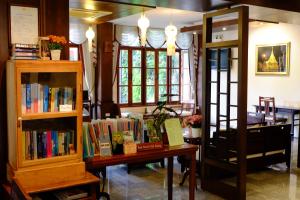 een kamer met een boekenplank met boeken erop bij Rainforest ChiangMai Hotel in Chiang Mai