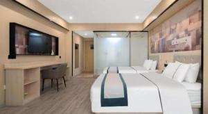 a bedroom with a large bed with a desk and a tv at City Comfort Inn Quanzhou Jinjiang Airport Yangguang Food Street in Jinjiang +118 photos