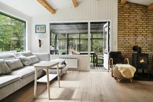 a living room with a couch and a table at Forest Vibe And Idyll On Møn in Stege