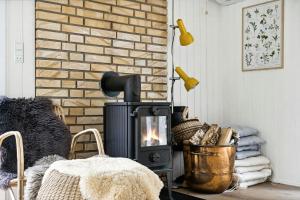 a fireplace in a living room with a brick wall at Forest Vibe And Idyll On Møn in Stege