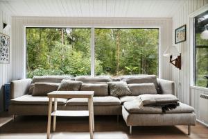 a living room with a couch and a large window at Forest Vibe And Idyll On Møn in Stege +27 photos