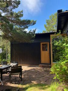 ein Haus mit einer Terrasse und einer Holztür in der Unterkunft Relaxing Archipelago Cottage Near Stockholm in Muskö