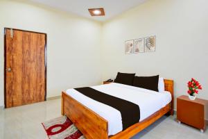 a bedroom with a bed and a wooden door at Collection O Chengicherla Hyderabad in Hyderabad