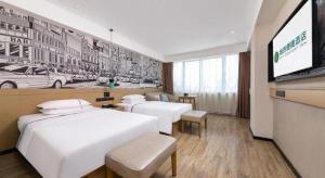 a hotel room with two beds and a flat screen tv at City Comfort Inn Haikou Zhongjie Road Walking Street in Haikou