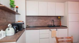 a kitchen with white cabinets and a sink at Flat Lora Pomorie in Pomorie