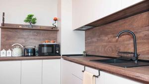 a kitchen with a sink and a microwave at Flat Lora Pomorie in Pomorie