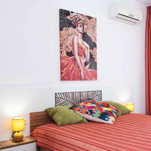 a bedroom with a bed with a painting on the wall at Flat Lora Pomorie in Pomorie