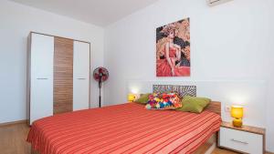 a bedroom with a large bed with a orange bedspread at Flat Lora Pomorie in Pomorie