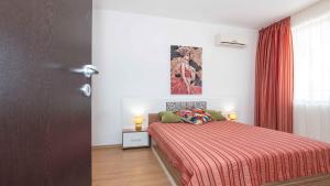 a bedroom with a bed with a red blanket at Flat Lora Pomorie in Pomorie
