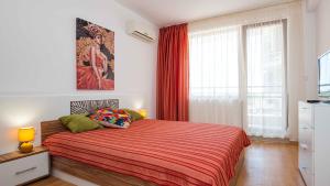 a bedroom with a bed with a red blanket at Flat Lora Pomorie in Pomorie