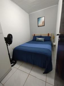 a bedroom with a blue bed and a camera at Casa dos Demeries in Triunfo