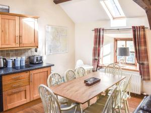 une cuisine et une salle à manger avec une table et des chaises en bois dans l'établissement Mount Cottage-Uk42230, à Low Borrowbridge
