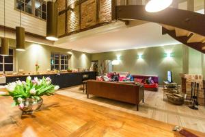 a living room with people sitting on couches in a room at Spacious Vacation Apartment With A Garden View in Walow +23 photos