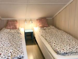 StabbestadにあるHistoric Farmhouse By The Archipelago Parkのテーブル付きの小さな部屋のベッド2台