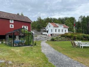 StabbestadにあるHistoric Farmhouse By The Archipelago Parkの赤い建物の隣の庭にあるガゼボ