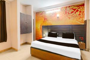 a bedroom with a large bed with a painting on the wall at Collection O Sharda Nagar Lucknow in Lucknow +16 photos