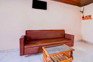 a brown leather couch sitting in a room with a table at Collection O Palava Dombivali in Mumbai