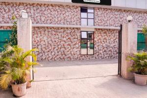 an open door to a building with two plants at Collection O Palava Dombivali in Mumbai