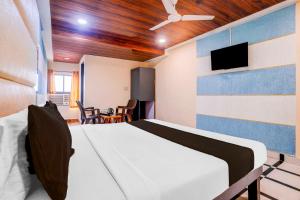 a bedroom with a bed and a tv on the wall at Collection O Palava Dombivali in Mumbai +8 photos