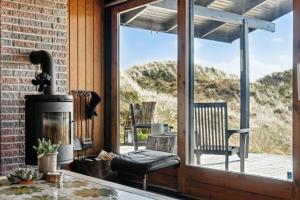 洛肯70'S Style Summerhouse Near Løkken的客厅设有壁炉和玻璃门。