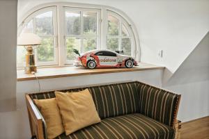 a car sitting on a window sill next to a couch at Nostalgic Charm In A Yellow Timber House in Sakskøbing