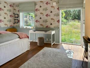 a bedroom with a bed and a table and a window at Your Archipelago Dream On Ingarö in Värmdö