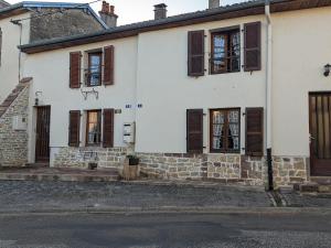 a white house with brown shuttered windows at Gîtes chaleureux près de Luxeuil, jardin commun - FR-1-583-472 in Vauvillers
