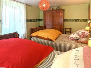 a bedroom with two beds and a chandelier at Charmante maison de village en Haute-Saône avec cheminée - FR-1-583-479 in Morey