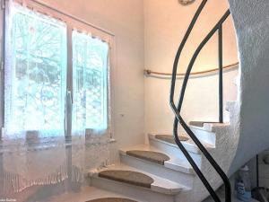 a set of stairs in a room with a window at Charmante maison de village en Haute-Saône avec cheminée - FR-1-583-479 in Morey