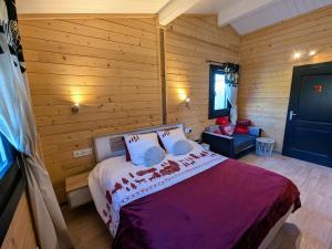 a bedroom with a bed in a wooden room at Chalet détente avec spa et sauna près des 1000 Étangs - FR-1-583-468 in La Vaivre
