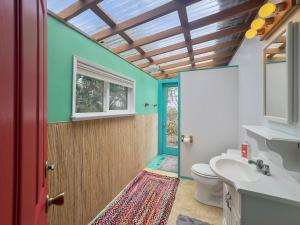 a bathroom with a toilet and a sink and a window at Best Ocean Views from Guesthouse in Hawaiian Ocean View Estates +96 photos