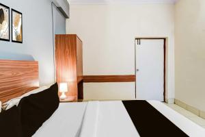 a bedroom with a large white bed with a wooden headboard at Collection O Paradise Circle in Hyderabad
