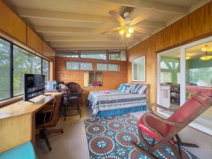 a bedroom with a bed and a desk with a computer at Best Ocean Views from Guesthouse in Hawaiian Ocean View Estates