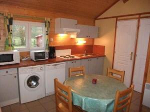 a kitchen with a table and a sink and a microwave at Chalet Édelweiss 35 en lisière de forêt, calme et nature - FR-1-583-444 in Mélisey