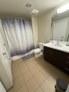 un baño con inodoro y lavabo en Poolside Palace, en Los Ángeles