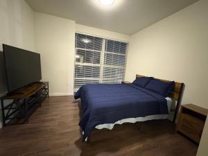 Un dormitorio con una cama y un televisor de pantalla plana. en Poolside Palace, en Los Ángeles