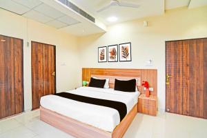 a bedroom with a large bed and wooden doors at Collection O Kalpi Road in Gwalior