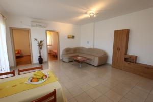 a living room with a couch and a table at Apartments Dudovic in Šilo