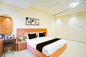 a bedroom with a bed and a desk and a bed sidx sidx sidx at Collection O Kalpi Road in Gwalior
