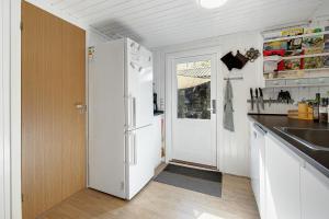 a kitchen with a white refrigerator and a sink at Idyllic Gem On Als Odde With Activities in Hadsund