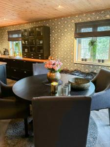 Un comedor con mesa y sillas y una cocina. en Sunny Cabin Near Gautefall, en Treungen