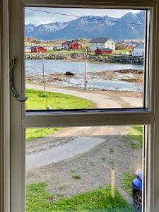 una ventana con vistas a una masa de agua en Red Cottage By The Sea In Laukvika, en Laukvik