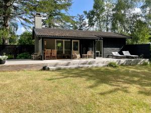 a small house with a porch and chairs on it at Charming Cottage Close To Smidstrup Beach in Gilleleje